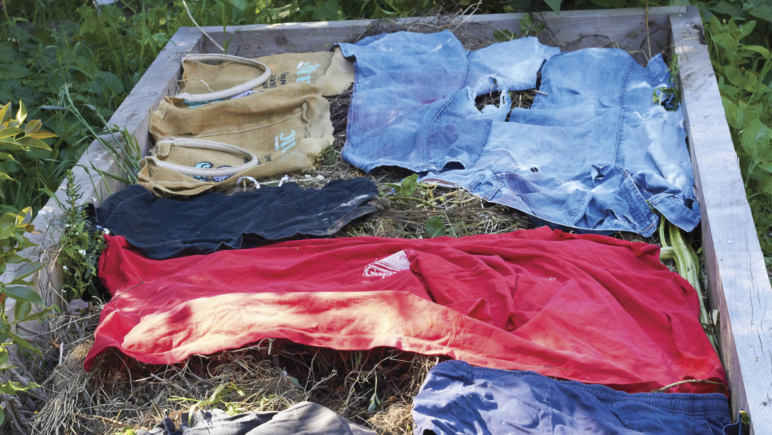 Olod clothes can be used on your garden bed as mulch; they will break down.